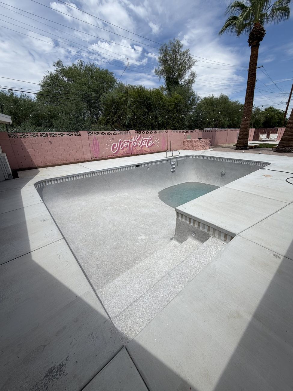 Freshly resurfaced pool shell filling with water during the remodel