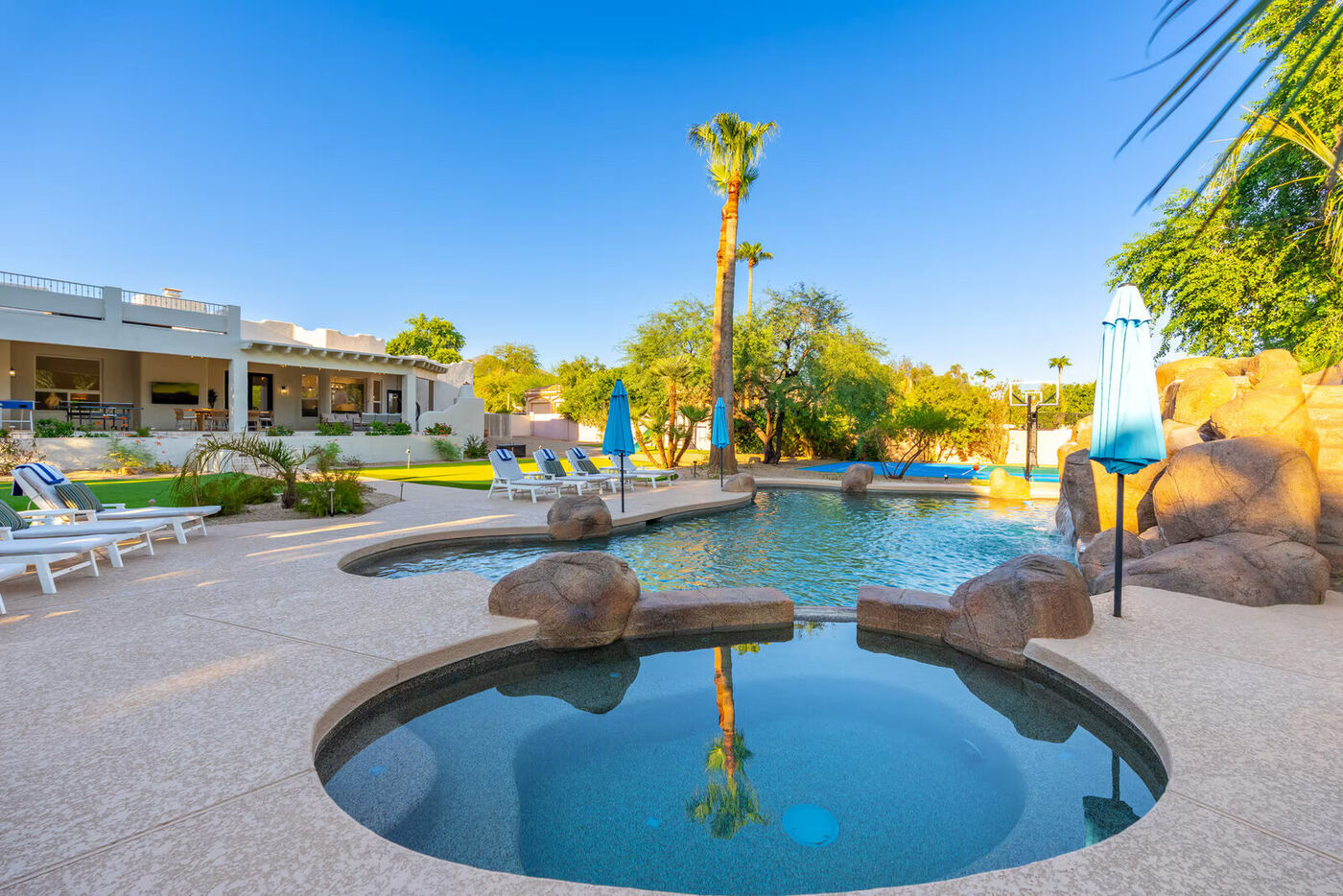 Before: the original pool, spa, and grotto waterfall at dusk