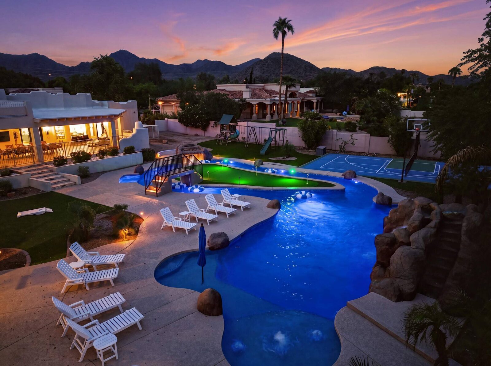 Poolside photo at blue hour with lounge furniture and the glowing lazy river